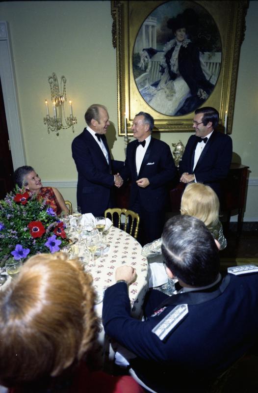President Gerald Ford, Secretary of Defense Donald Rumsfeld, and Deputy Secretary of Defense William Clements attend a dinner for the Secretary of Defense, Service Secretaries, Joint Chiefs of Staff, and Commanders or the Unified Commands in the White House State Dining Room, 12/11/1976.