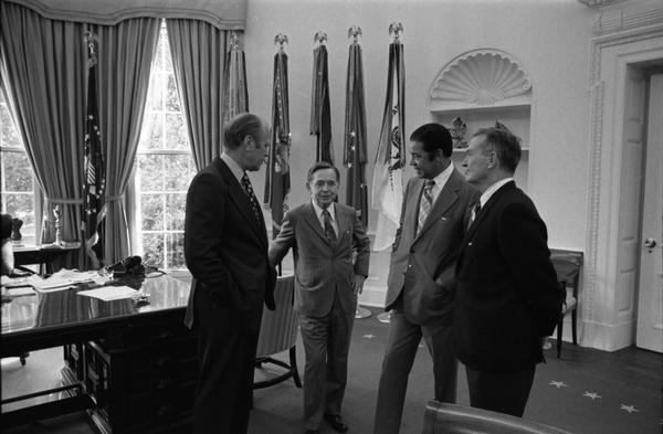 President Gerald Ford, Assistant Secretary of Defense William Clements, Representative Carl Albert, and Senator Edward Brooke discuss the Combined Federal Campaign in the Oval Office, 9/17/1974.